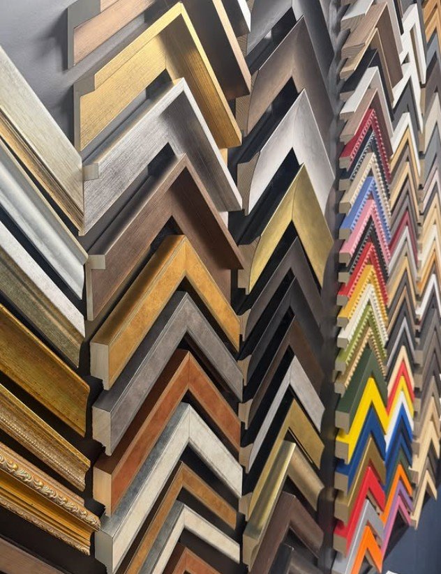 Wall display of picture frame moulding and mount samples in dozens of finishes